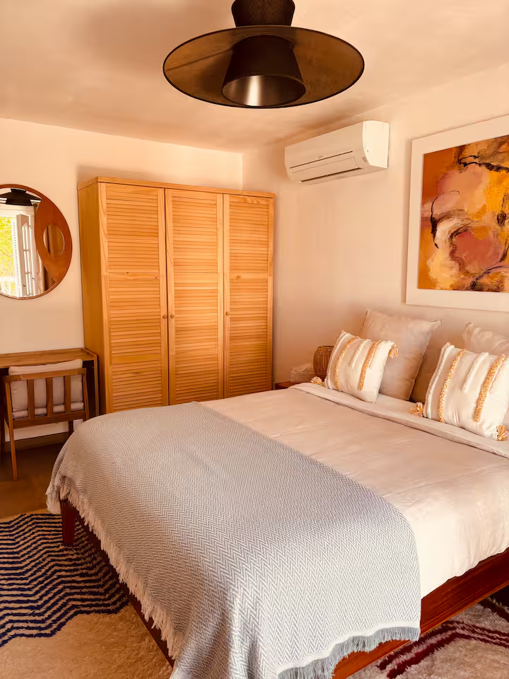 Bedroom with louvred wardrobe and Berber rug