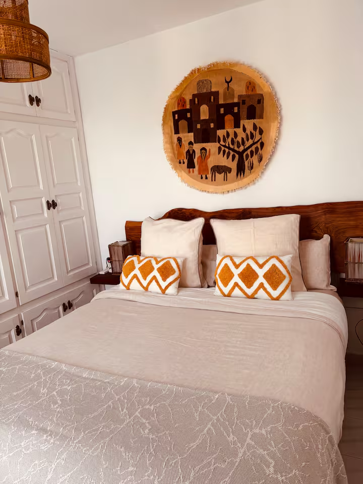 Bedroom with carved headboard and woven wall piece